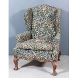 An Early 20th Century Wingback Easy Chair of "18th Century" Design, upholstered in tapestry, on leaf