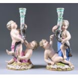 A Pair of Meissen Porcelain Figural Candlesticks, 19th Century, each modelled as two putti holding