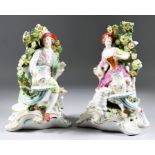 A Pair of Continental Porcelain Candlestick Figures, 19th Century, in Chelsea manner, 10ins high,