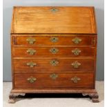 A George III Mahogany Bureau, the slope enclosing shaped and stepped interior, fitted eight small