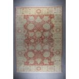 A Modern Indian Carpet, woven in pastel shades, fawn, bold palmettes and floral ornament on a