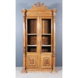 A 19th Century French Walnut Display Armoire, the moulded cornice with shaped pediment with carved