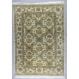 A Modern Indian Carpet, woven in muted colours, the field filled with floral splays, on an ivory