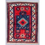 A Kazak Fakhralu prayer rug woven in colours with a central mihrab filled with hooked lozenge-shaped