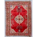 A Karabagh Chanlyk rug woven in colours with a central flower filled medallion and conforming