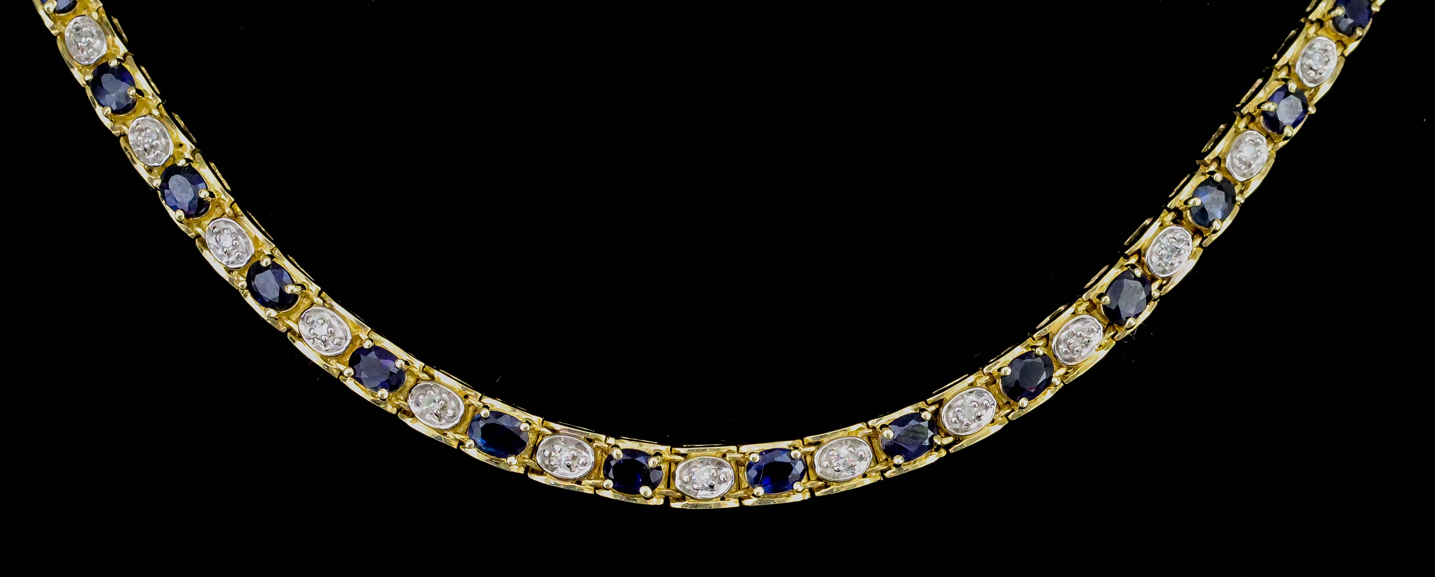 A Sapphire and Diamond Line Necklace, Modern, in gold coloured metal mount, set with forty-three