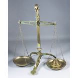 A Set of Brass Balance Scales, Late 19th Century, with turned column and tripod base, 25.75ins high,