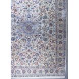 A Kashan Carpet, woven in pastel shades of blues, reds, burnt orange, green and fawn with a bold
