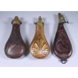 Six Powder Flasks, 19th Century, including - copper with shell embossed sides, 8ins, pressed leather