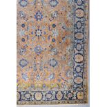 A Tabriz Carpet, woven in pale blue, dark blue, rose, fawn and ivory with palmettes and trailing