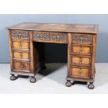 An Early 20th Century Panelled Oak Kneehole Desk, with brown tooled leather inset to top, fitted