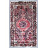 A Hamadan Long Rug, Modern, woven in muted colours with a central pole medallion on a dark ground,