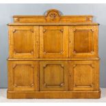 A Late Victorian Oak Two-Tier Dwarf Cupboard, with shaped and moulded back applied with shield