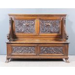 A Late 19th Century Continental Carved Oak Hall Bench, the twin panelled back baldly carved with