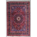 A Heriz Rug, Mid 20th Century, woven in colours with a bold floral medallion with conforming