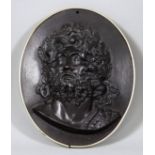 A Cast Iron Oval Plaque, moulded in relief with a bearded classical figure, 11ins x 9ins, in later