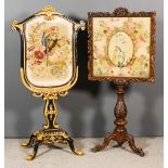 Two Victorian Fire Screens, one in ebonised and gilt, inset with Berlin work panel depicting a