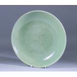 A Chinese Celadon Dish, the centre with incised flower design, the rim with incised border, 12ins (