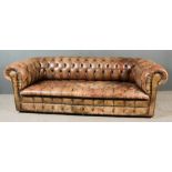 A Three-Seat Chesterfield Settee, upholstered in antique dark red leather, the seat and back deep