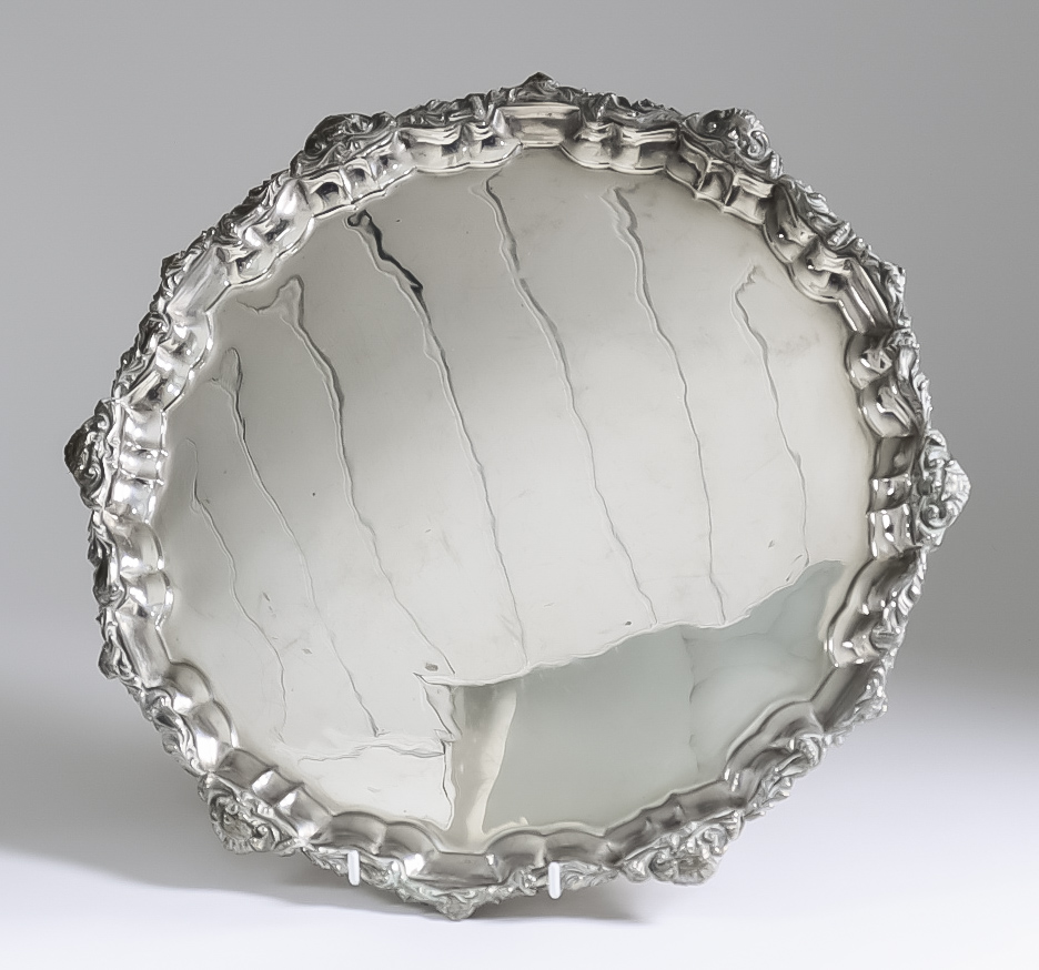 A 20th Century Egyptian Silvery Metal Circular Tray, the moulded piecrust rim with bold cast mask