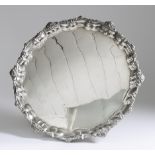 A 20th Century Egyptian Silvery Metal Circular Tray, the moulded piecrust rim with bold cast mask