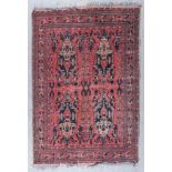 A Turkmen Rug, Early 20th Century, woven in wine and navy blue, the field filled with four