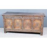 A 17th Century Panelled Oak Coffer, with plain lid, the four panel front later carved with