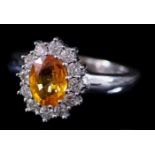 A Yellow Sapphire and Diamond Ring, Modern, in 18ct white gold mount, the centre set with a yellow