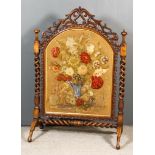 A Victorian Walnut Framed Fire Screen, the centre panel embroidered in cut woolwork with a spray