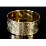 A 9ct Gold Stiff Bracelet, 20th Century, the face engraved with floral motif, 205mm circumference