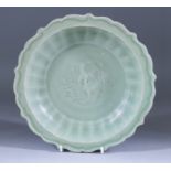 A Chinese Celadon Barbed Dish, the centre carved with a phoenix design, 10.25ins (26cm) diameter