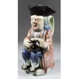 A Wood Family Pearlware Toby Jug, circa 1790, of traditional form, seated and holding a jug,