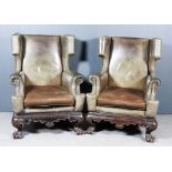 A Pair of 20th Century Mahogany Framed High Wingback Easy Chairs, the shaped wings with