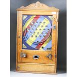 A 1950's Oak Cased Alwin Flicker Machine (to take pennies), with chevron ground in red, blue and