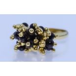 An 18ct Gold Articulated Ring, Modern, set with alternating black stones and gold spheres, size M,