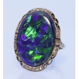 An Opal and Diamond Ring, in platinum mount, set with a black opal, 23mm x 16mm, surrounded by