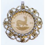 A South African 1986 Krugerrand, in 9ct gold floral decorated pendant mount surrounded by paste