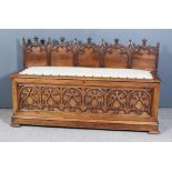 A Victorian Panelled Walnut Box Seat in the Pugin Manner, with carved Gothic arch back, the seat