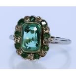 An Emerald and Diamond Ring, Modern, in platinum mount, set with a centre emerald, approximate