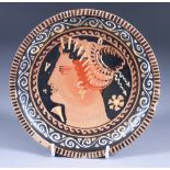 A Gnathian Red Figure Plate on High Foot, 4th Century BC, painted with a female profile head wearing