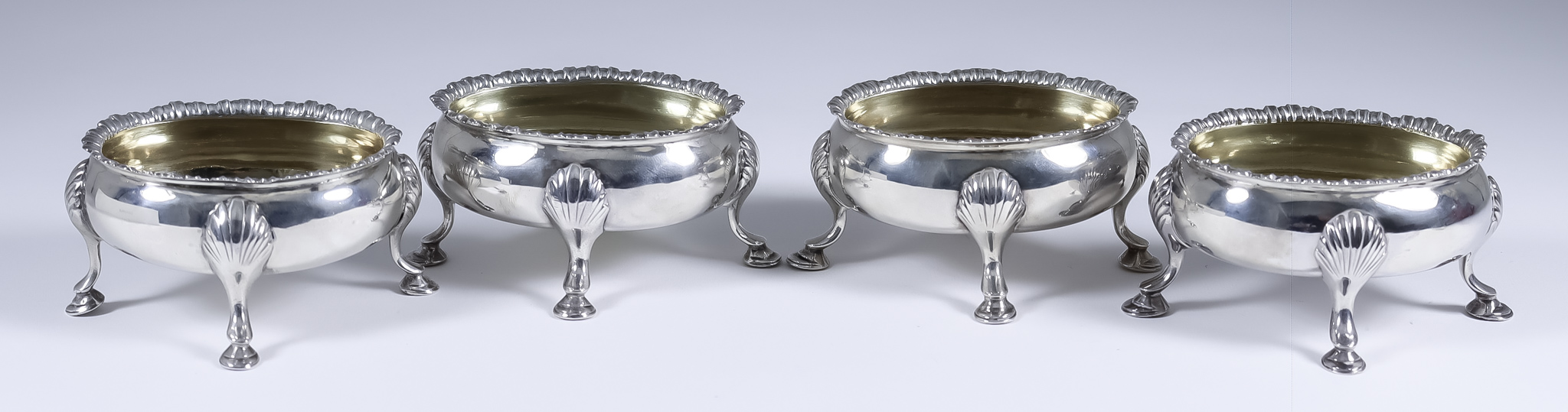 A Harlequin Set of Four George III and Victorian Silver and Silver Gilt Oval Salts, three by