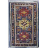 A Daghestan Rug woven in colours with three bold stepped medallions filled with cross motifs on a