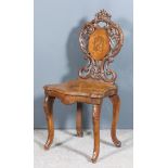 A 19th Century Swiss Walnut Musical Chair, with bold leaf and fretted carved back of shaped outline,