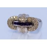 An 18ct White Gold Diamond and Sapphire Ring, Modern, in the form of intertwined circles, the centre
