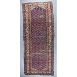 An Antique Fereghan Long Rug, woven in colours, the field filled with twelve rows of hooked boteh on