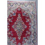 A Kirman Carpet, Mid 20th Century, woven in colours, with a bold central floral medallion and