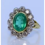 An Emerald and Diamond Ring, Modern, in 18ct gold mount, set with a central faceted emerald,
