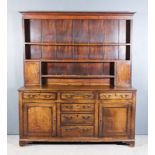 An 18th Century Panelled Oak Dresser, the upper part with moulded cornice, fitted three open shelves