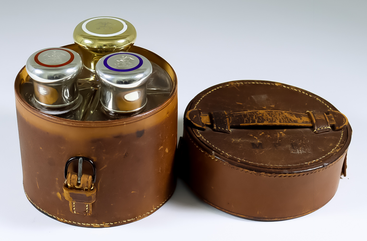 A Set of Three Victorian Gentleman's Silver, Silver Gilt and Enamel Topped Glass Cologne Bottles, by