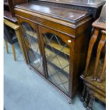 AN OAK BOOKCASE WITH TWO LEAD GLAZED DOORS (ONE PIECE OF GLASS MISSING) AND AN OPEN BOOKCASE WITH